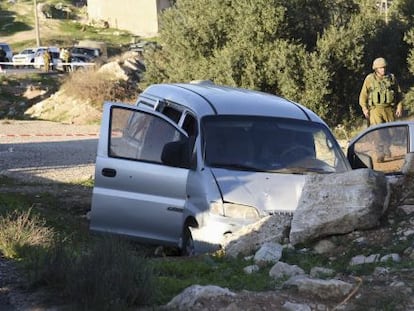 Dos militares israelíes cerca del coche tiroteado en Hebrón este viernes.
