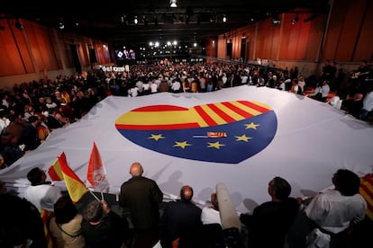 Simpatizantes de Ciudadanos despliegan una pancarta con las banderas de España, Cataluña y Europa, en el mitin de cierre de campaña en Barcelona.