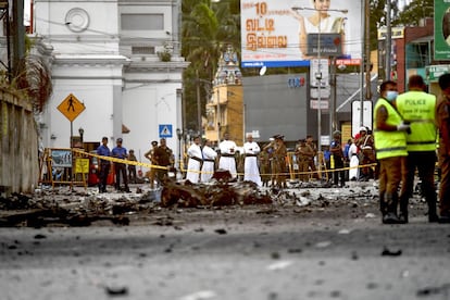 Un grupo de sacerdotes miran los escombros de un automóvil cerca del Santuario de San Antonio, en Colombo, el 22 de abril de 2019, un día después de la serie de los atentados múltiples en iglesias y hoteles de lujo en Sri Lanka.