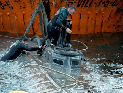 Spanish Civil Guard divers stand over the “narco-submarine.”