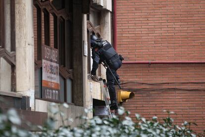 Un agente de la policía autonómica accede a la vivienda por una ventana.
