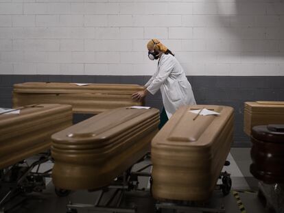 Un trabajador de una funeraria reparte varios féretros