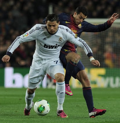 Pedro intenta arrebatrle la pelota a Cristiano Ronaldo.