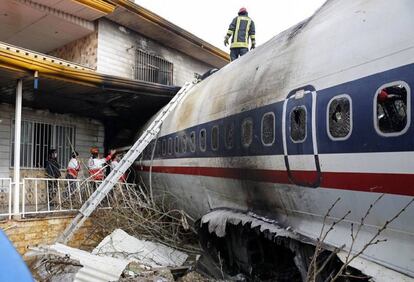 Miembros de los servicios de emergencia trabajan junto al fuselaje de un avión de carga que se ha estrellado en Karag, al oeste de Teherán (Irán).