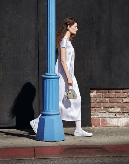 <p>Vestido de seda corte imperio de Fontana (Squaresville), pendientes de goma y diamantes de Laura Biagiotti, doble monedero de pedrería de dos tamaños de Schiaparelli, y calcetines de deporte y zapatillas Vans. Polvos compactos All Hours Setting Powder, de Yves Saint Laurent. </p><br><p>Maquillaje y peluquería: María Martínez (Kasteel Agent). Director de casting: David Chen. Producción: Nick Blumenthal (ArtWorld Agency). Modelo: Carolina Burgin (The Society Management).</p>