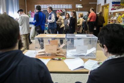 Un grupo de votantes espera su turno para poder depositar su papeleta en una de las mesas electorales del colegio público Padre Coloma de Madrid.