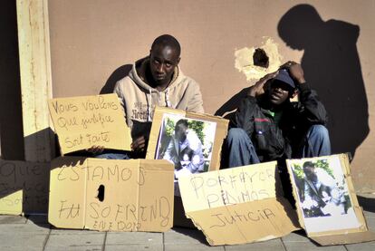 Un grupo de subsaharianos exhibe fotos del senegalés muerto y muestra carteles reclamando justicia en el lugar en que se cometió el crimen.