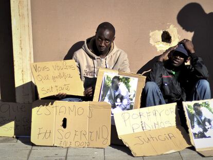 Un grupo de subsaharianos exhibe fotos del senegalés muerto y muestra carteles reclamando justicia en el lugar en que se cometió el crimen.