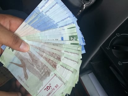 Un hombre muestra uno de los billetes con el sello de 'El Chapo' Guzmán.