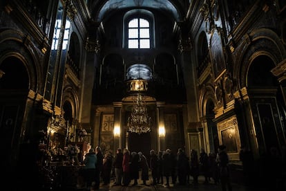 Un grupo de fieles hace cola en el templo de Pochayiv para besar una roca donde, según la leyenda, la Virgen María dejó una huella tras descender de los cielos para ayudar a los habitantes de la localidad en 1675, durante la invasión turca.