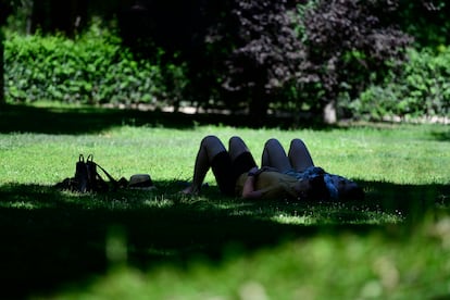 Dos personas descansan bajo una sombra en el Parque de El Retiro de Madrid, el pasado fin de semana.