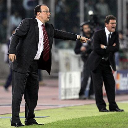 Los entrenadores del Liverpool, Benítez, y de la Juve, Capello, dan órdenes a sus jugadores.