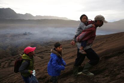 Un hombre lleva a su hijo a la celebración del 'Yadnya Kasada', la festividad más importante para la étnia Tengger. Dura aproximadamente un mes. El 14avo día de la Kasada, la población Tengger sube al Monte Bromo para pedir su bendición a la deidad 'Hyang Widi Wasa y Mahadeva', o dios de las montañas.