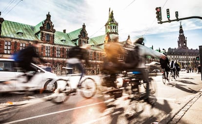 Ciclistas en Copenhague, con el edificio de la Bolsa al fondo.