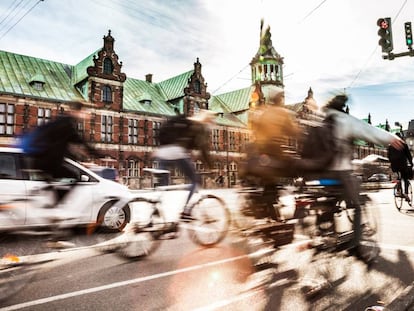 Ciclistas en Copenhague, con el edificio de la Bolsa al fondo. 