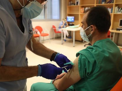 Un trabajador sanitario inyecta una dosis de la de Pfizer-BioNTech contra la covid-19 a otro sanitario en un hospital de Madrid.