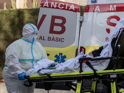 Un sanitario atiende a un enfermo frente a una residencia de la Eliana (Valencia), el lunes.
