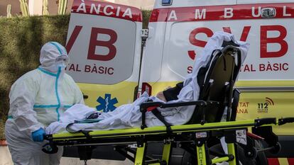 Un sanitario atiende a un enfermo frente a una residencia de la Eliana (Valencia), el lunes.