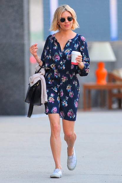 Vestido de flores, zapatillas blancas y gafas redondas, una mezcla que funciona para el día a día. Palabra de Sienna Miller.