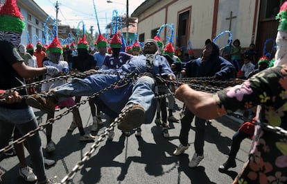 Un grupo de hombres simula la captura de Judas, a quien llevan encadenado en las calles de Managua.