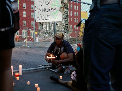 Raquel Sipp kneels with a candle at the scene of where an apartment building partially collapsed two days earlier, in Davenport, Iowa