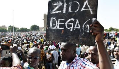 Un hombre porta un cartel con la frase &quot;Zida, m&aacute;rchate&quot;, en referencia al militar que ha asumido la jefatura del Estado.