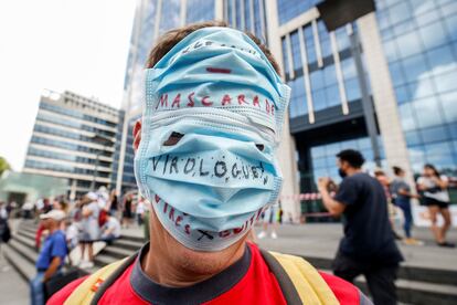 Un manifestante luce una mascarilla con el mensaje "Mascarada, virología" durante una protesta contra las medidas de seguridad gubernamentales impuestas para combatir la pandemia del Covid-19, en Bruselas, Bélgica, en 2020.