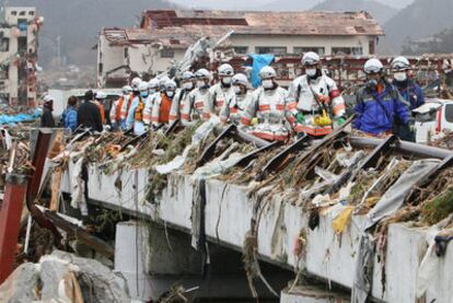 Personal de emergencias rastrea la ciudad de Minami Sanriku, de la que se dan por desaparecidos la mitad de sus habitantes, en busca de supervivientes.