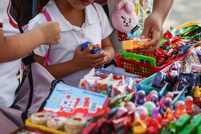 Niños compran dulces afuera de una escuela