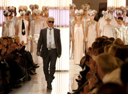 Lagerfeld saluda al término del desfile. Abajo, modelos de Chanel y Armani.