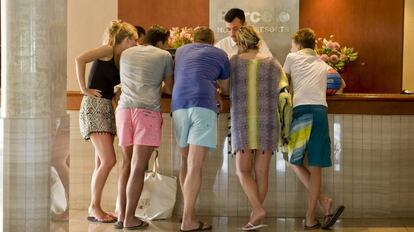 Turistas en la recepci&oacute;n de un hotel en Baleares.