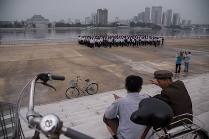 Un par de turistas sacando fotos en el río Taedong, en Pyongyang.