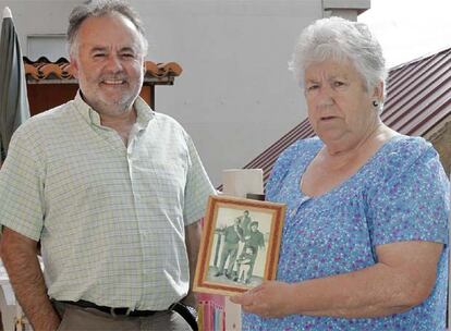 Chema Hermelo y María Domínguez en su casa de Vilariño, junto a un retrato de los 60 en el que aparece Pepe O Pequeno (izquierda) .