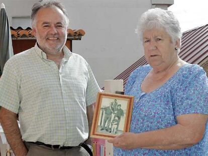 Chema Hermelo y María Domínguez en su casa de Vilariño, junto a un retrato de los 60 en el que aparece Pepe O Pequeno (izquierda) .