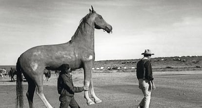La imagen del vaquero John Wayne, inmortalizada en 1959 durante el rodaje de El &Aacute;lamo. Detr&aacute;s, un atrezista con un caballo de cart&oacute;n piedra a la medida del actor. 