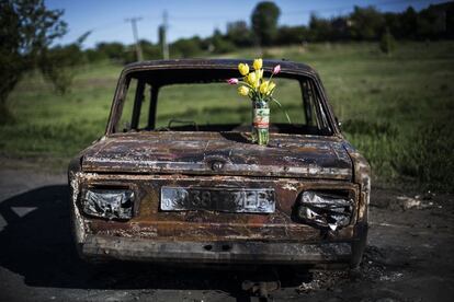 Un ramo de flores sobre los restos de un coche quemado durante los enfrentamientos entre rebeldes prorrusos y el ejército ucranio al norte de Slovyansk.