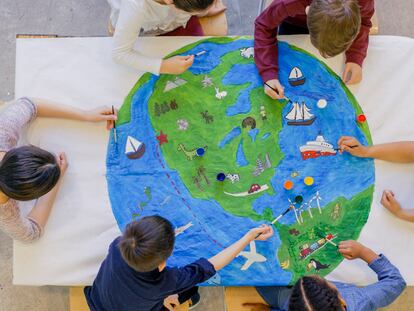 Unos niños dibujan la Tierra en clase