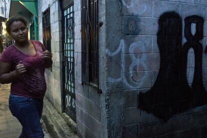 Una adolescente camina frente a un grafitti de la pandilla 18ST. El pasado julio, esta pandilla provocó la paralización del transporte público y asesinó a nueve conductores de autobús en tres días.