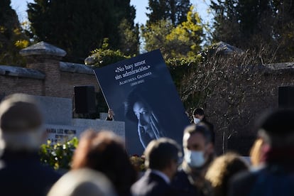 Una persona porta un cartel en homenaje a la escritora Almudena Grandes, en el cementerio de la Almudena, en Madrid.