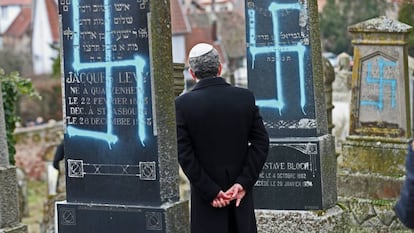 Un hombre contempla las lápidas vandalizadas  en el cementerio judío de Quatzenheim (Francia).