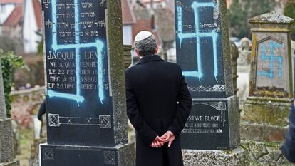 Un hombre contempla las lápidas vandalizadas  en el cementerio judío de Quatzenheim (Francia).