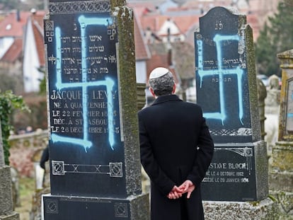 Un hombre contempla las lápidas vandalizadas  en el cementerio judío de Quatzenheim (Francia).