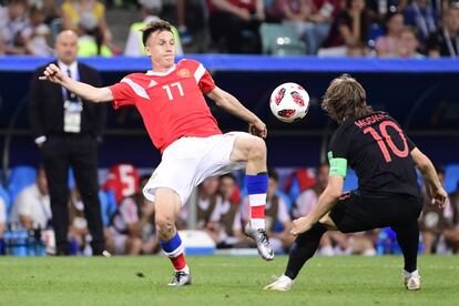  Aleksandr Golovin y Luka Modric pelean un balón.