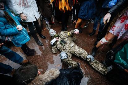 Una persona vestida como un soldado participa en una batalla simbólica entre humanos y zombis durante un desfile de Halloween en el centro de Kiev, (Ucrania), el 30 de octubre. 