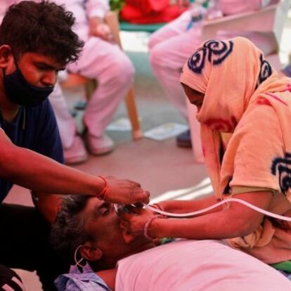 Family members of Nanhe Pal, 52, who is suffering from breathing problem, provides him oxygen support for free at a Gurudwara (Sikh temple), amidst the spread of coronavirus disease (COVID-19), in Ghaziabad, India, May 3, 2021. REUTERS/Adnan Abidi