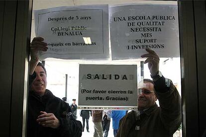 Dos personas protestan por retrasos en colegios, ayer en  Alicante.