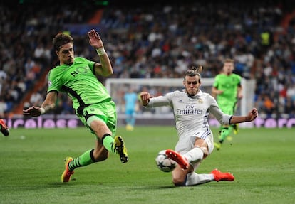 Gareth Bale del Real Madrid (d) intenta para el balón con la presencia de Sebastian Coates del Sporting.