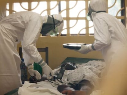 O doutor Brantly (esquerda) trata um paciente de ebola.