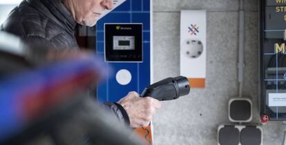 Un hombre carga su vehículo eléctrico.