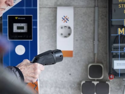 Un hombre carga su vehículo eléctrico. 